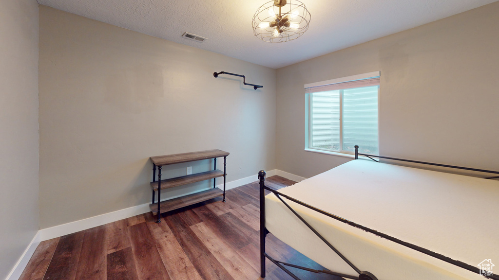 Bedroom featuring a textured ceiling and dark hardwood / wood-style flooring