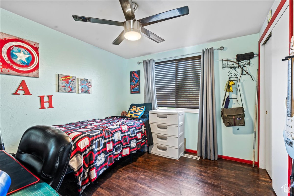 Bedroom with ceiling fan and dark wood-type flooring