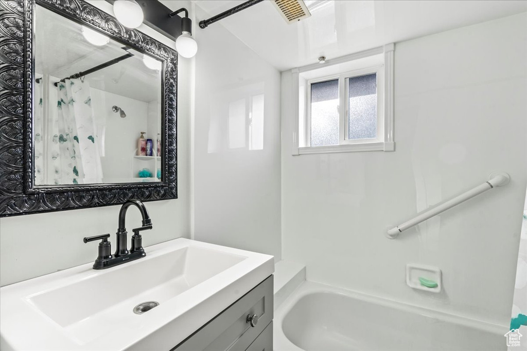 Bathroom with shower / bath combo and vanity