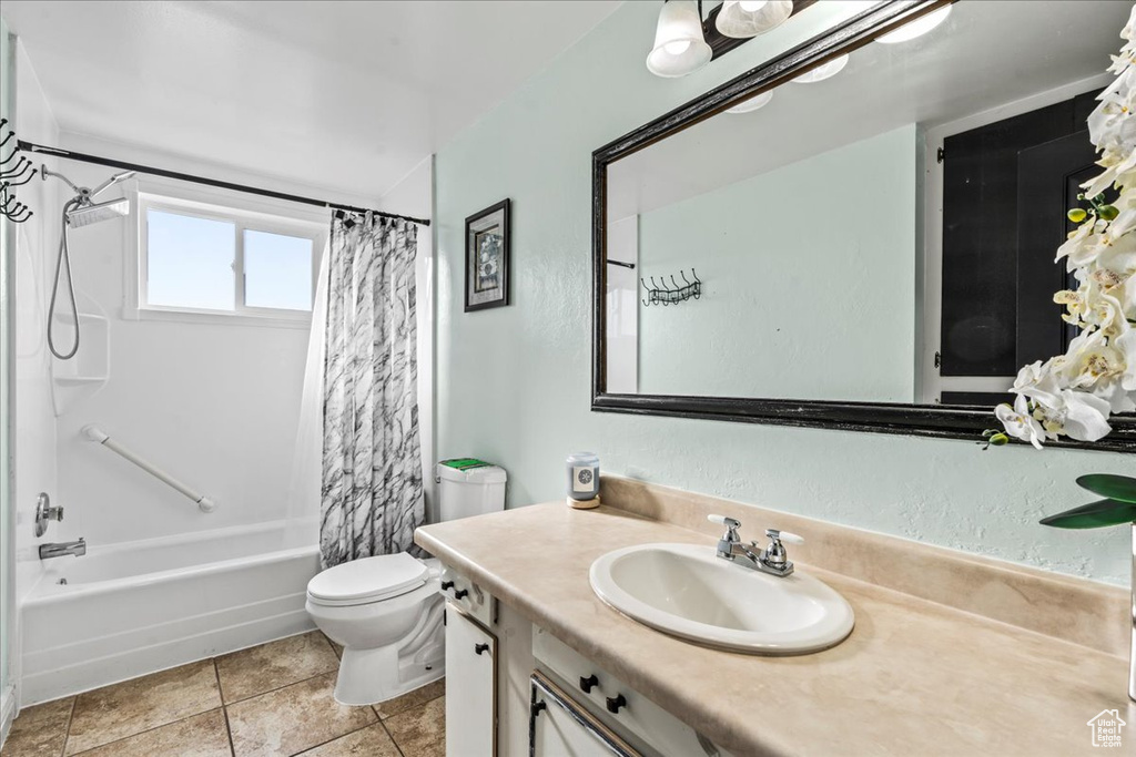 Full bathroom featuring shower / bath combo, tile flooring, oversized vanity, and toilet