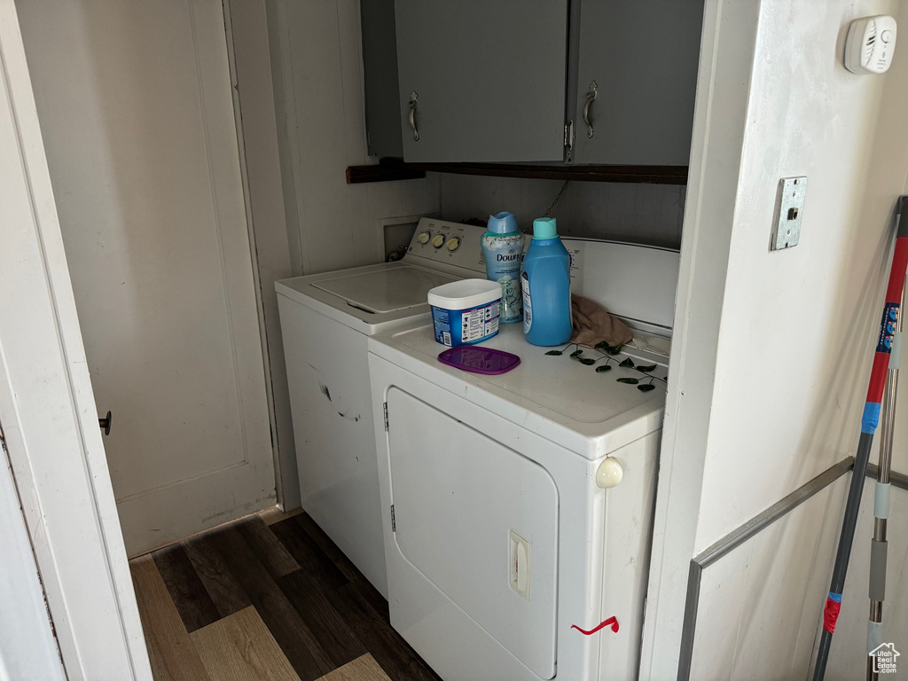 Laundry area with cabinets, dark wood-type flooring, and independent washer and dryer