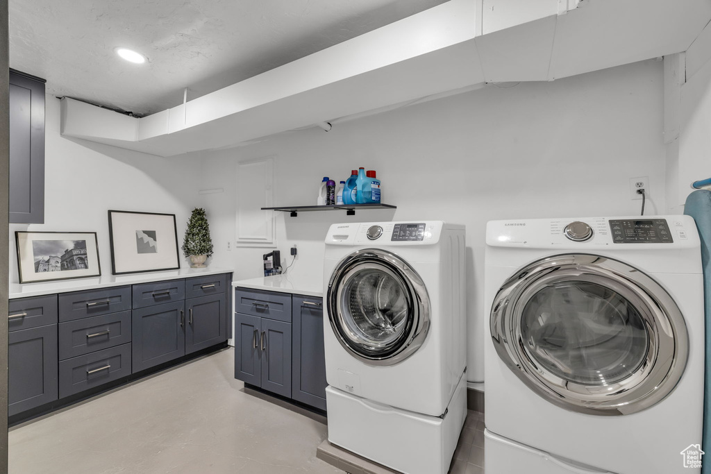Laundry room featuring washer and clothes dryer and cabinets