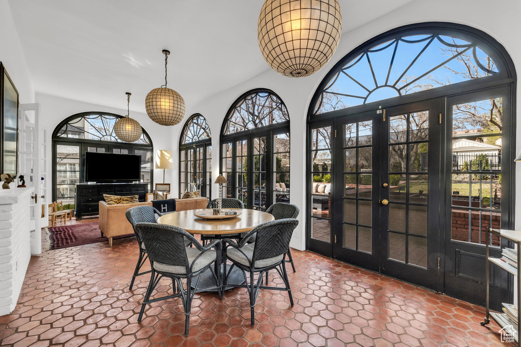 Dining area with dark tile floors, french doors, and a wealth of natural light