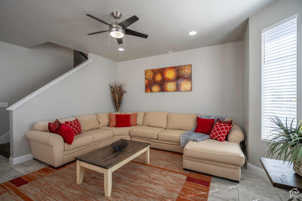 Tiled living room featuring a wealth of natural light and ceiling fan