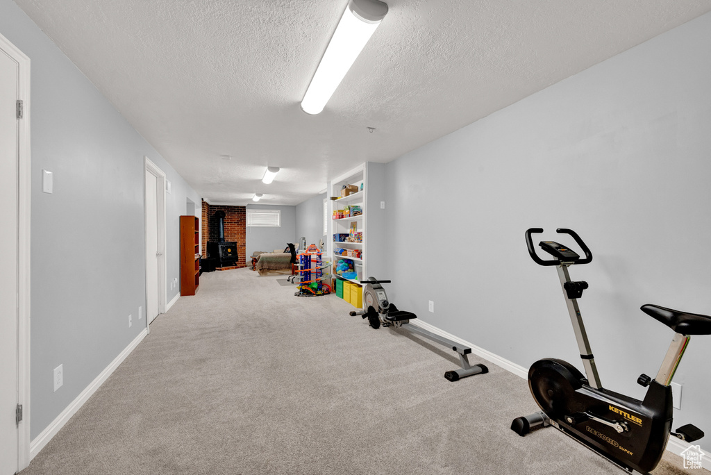 Exercise room featuring carpet flooring and a textured ceiling