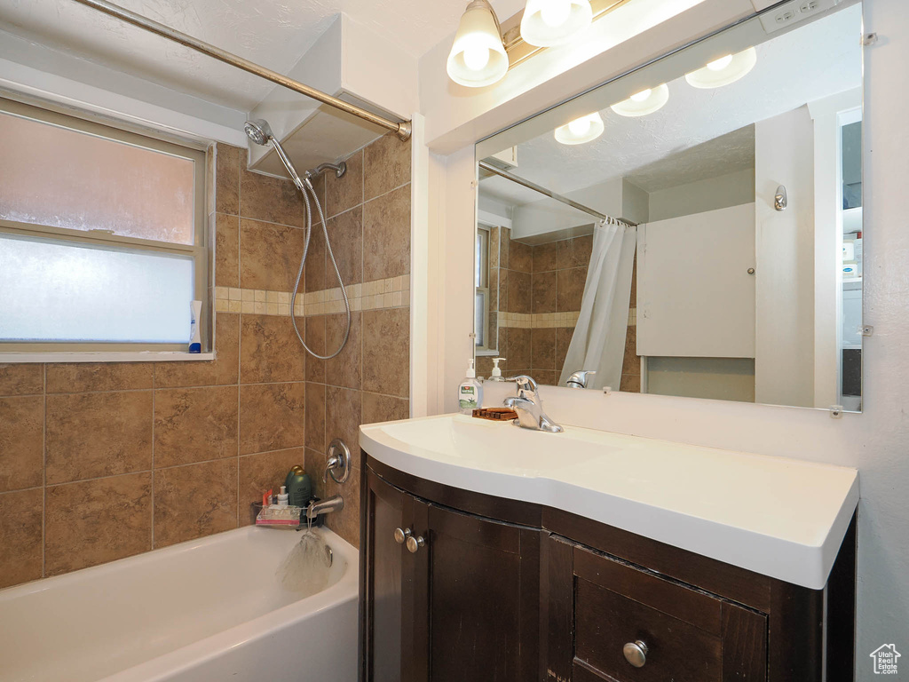 Bathroom with shower / bathtub combination with curtain and vanity