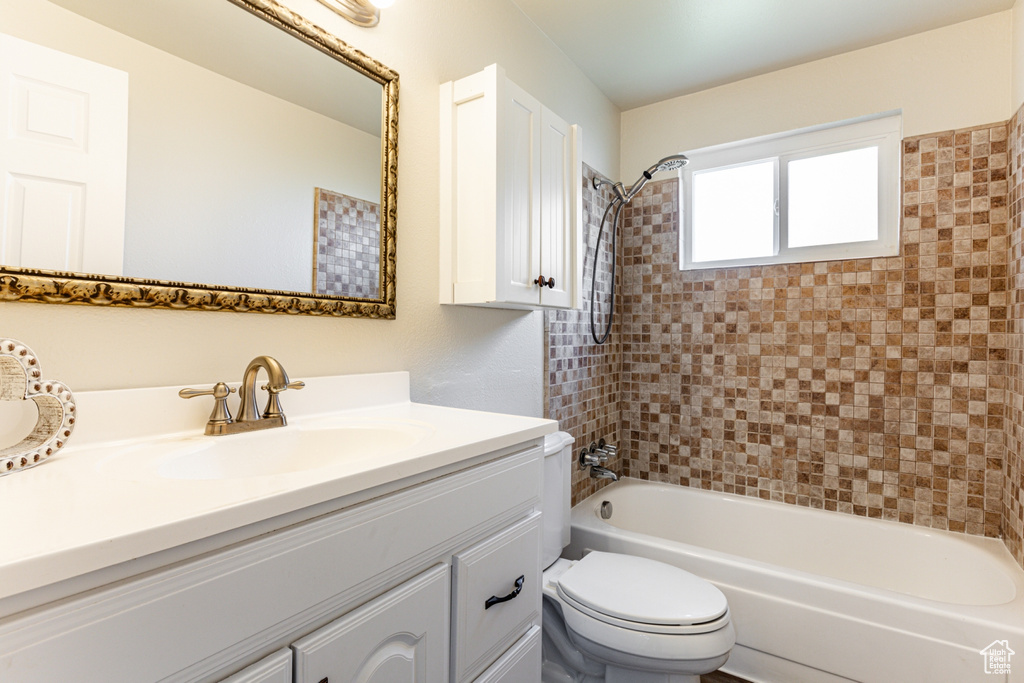 Full bathroom with tiled shower / bath, toilet, and oversized vanity