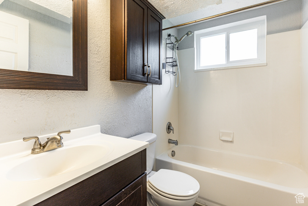 Full bathroom featuring shower / tub combination, toilet, vanity, and a textured ceiling