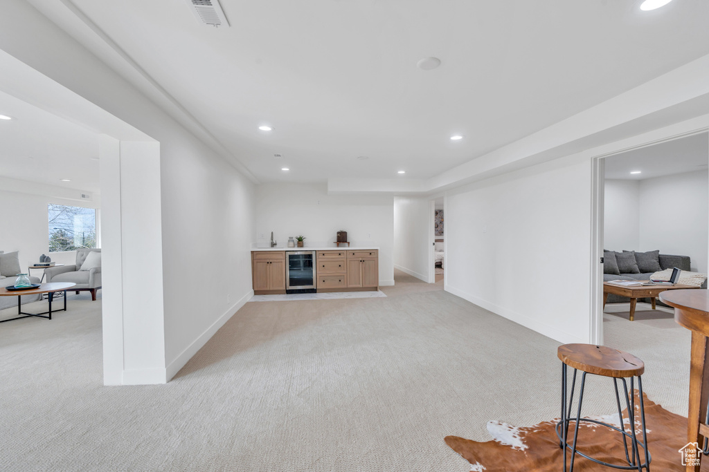 Interior space featuring wine cooler and light carpet