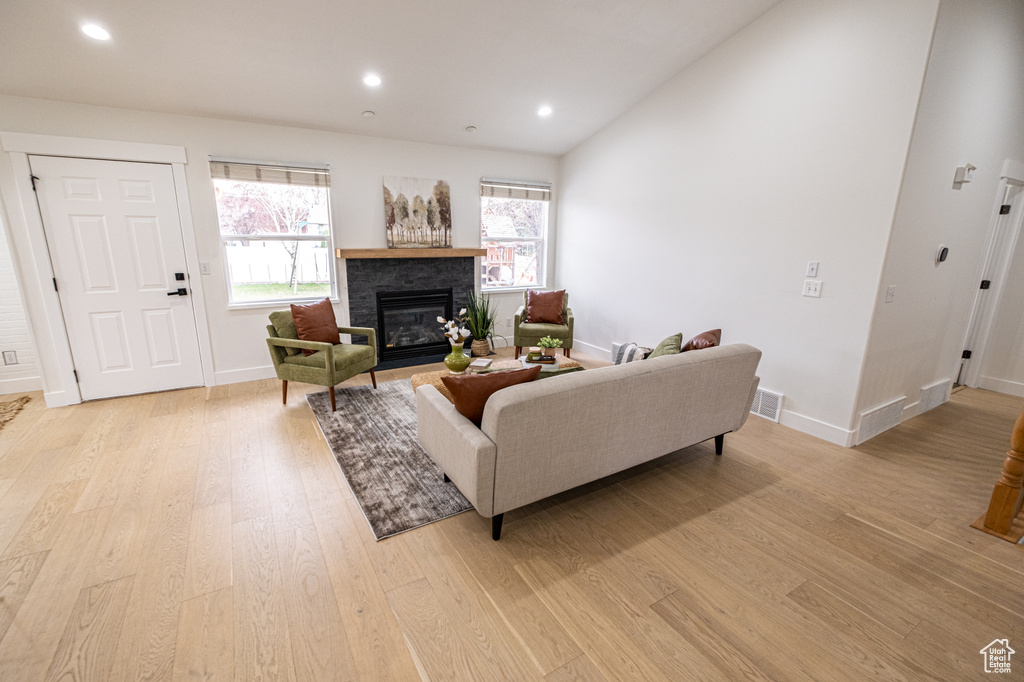 Living room featuring vaulted ceiling and light hardwood / wood-style flooring