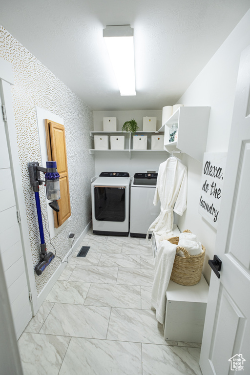 Laundry area with light tile flooring and independent washer and dryer