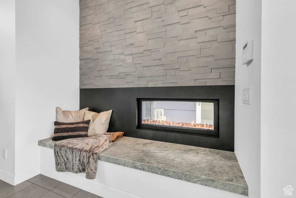 Interior details featuring dark tile floors and a multi sided fireplace