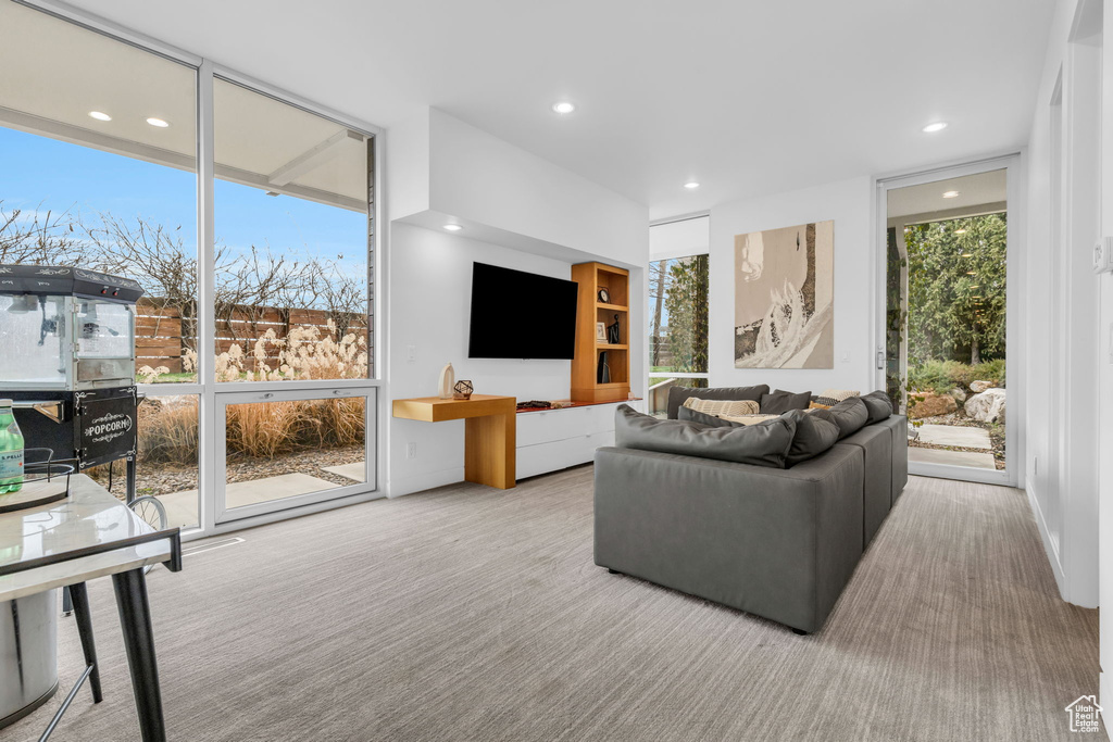 Carpeted living room featuring floor to ceiling windows