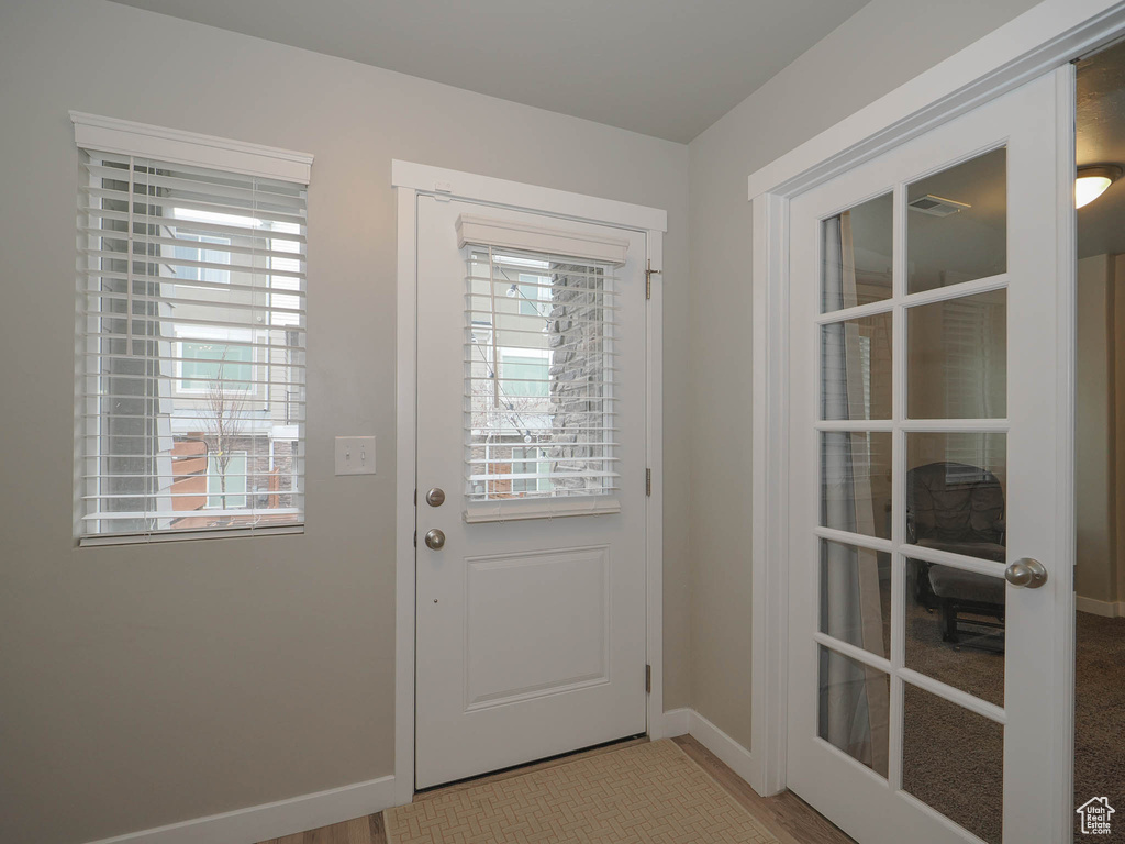 Entryway featuring french doors, light hardwood / wood-style floors, and a wealth of natural light