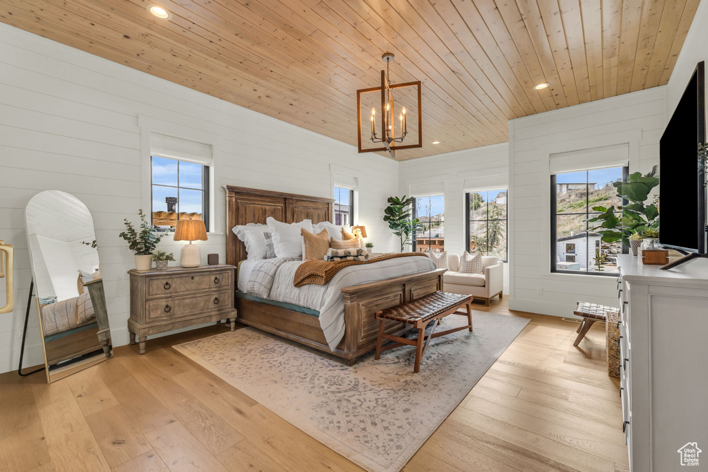 Bedroom featuring light hardwood / wood-style floors, a notable chandelier, and wood ceiling
