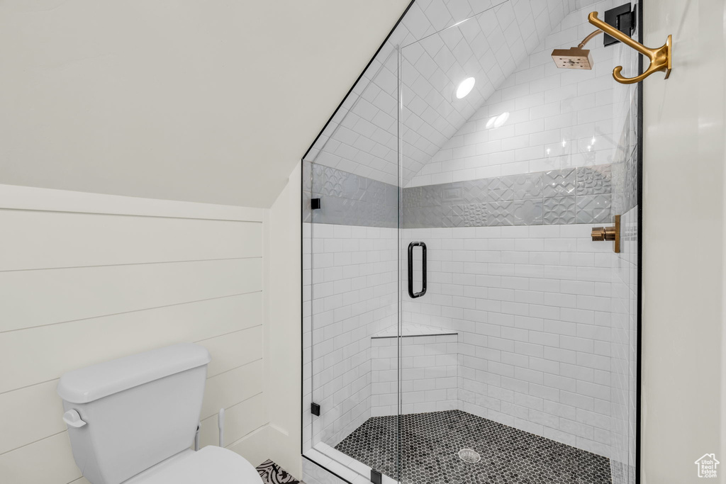 Bathroom with lofted ceiling, toilet, and walk in shower