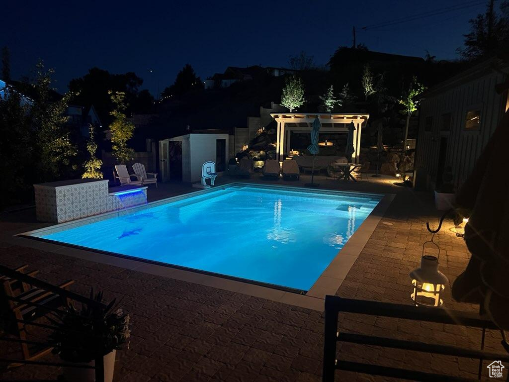 Pool at twilight featuring a pergola and a patio