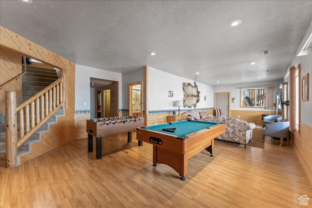 Game room featuring a textured ceiling, pool table, and light wood-type flooring
