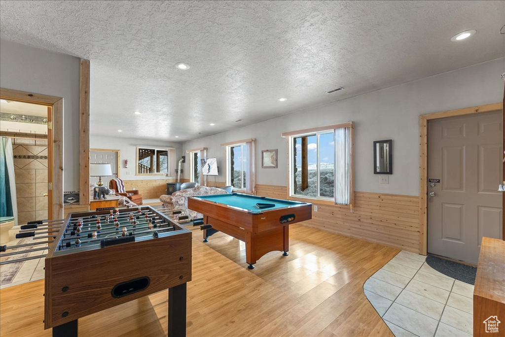 Playroom featuring light tile floors, a textured ceiling, and pool table