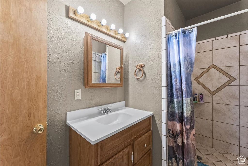 Bathroom with curtained shower and vanity
