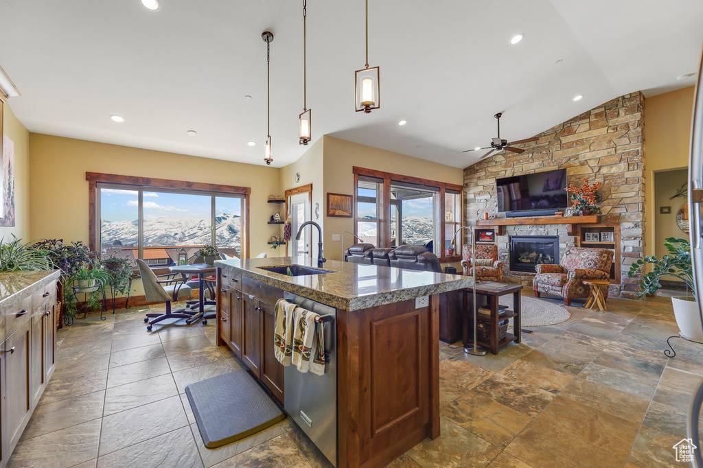Kitchen with plenty of natural light, a fireplace, ceiling fan, and decorative light fixtures