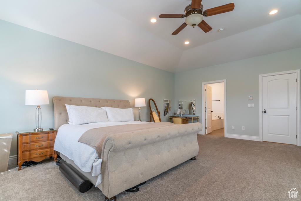 Carpeted bedroom with connected bathroom, lofted ceiling, and ceiling fan