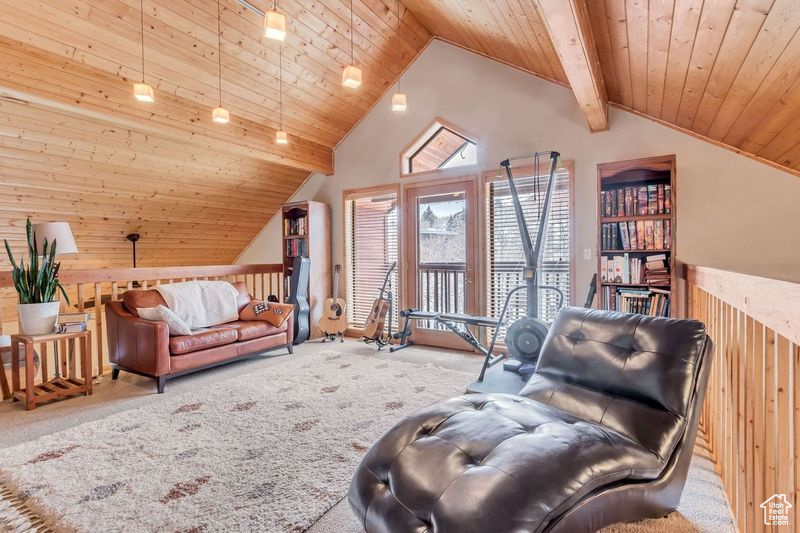 Carpeted living room with wooden walls, wooden ceiling, high vaulted ceiling, and beam ceiling