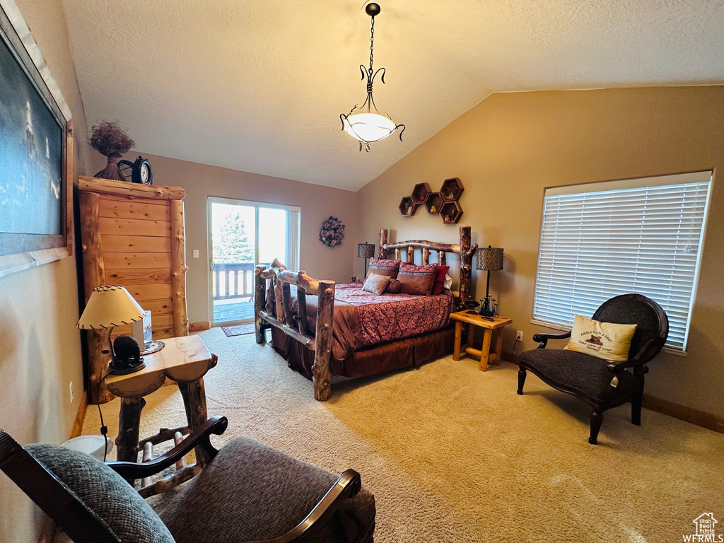 Bedroom with a textured ceiling, access to exterior, vaulted ceiling, and light colored carpet