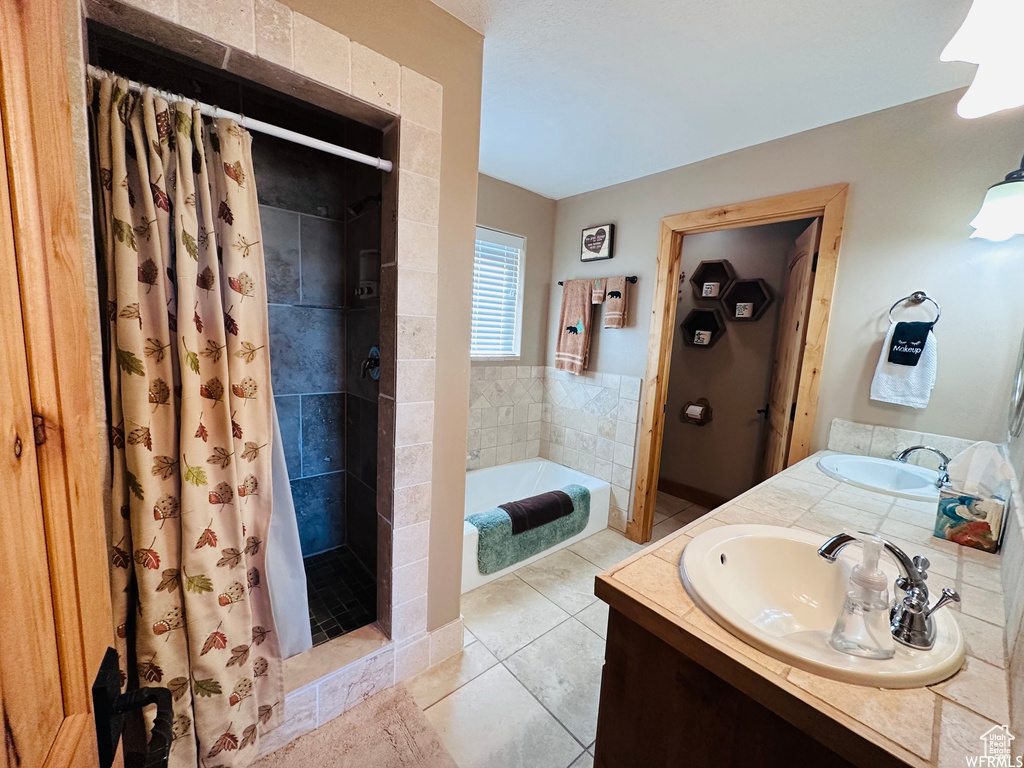 Bathroom with tile floors, shower with separate bathtub, and vanity