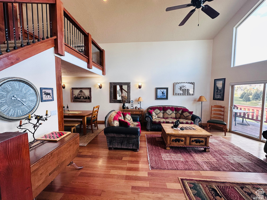 Living room featuring a high ceiling, hardwood / wood-style floors, and ceiling fan