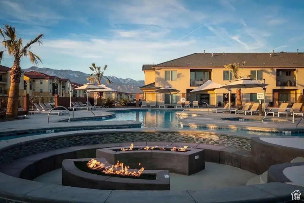 View of swimming pool featuring a mountain view, a fire pit, and a patio area