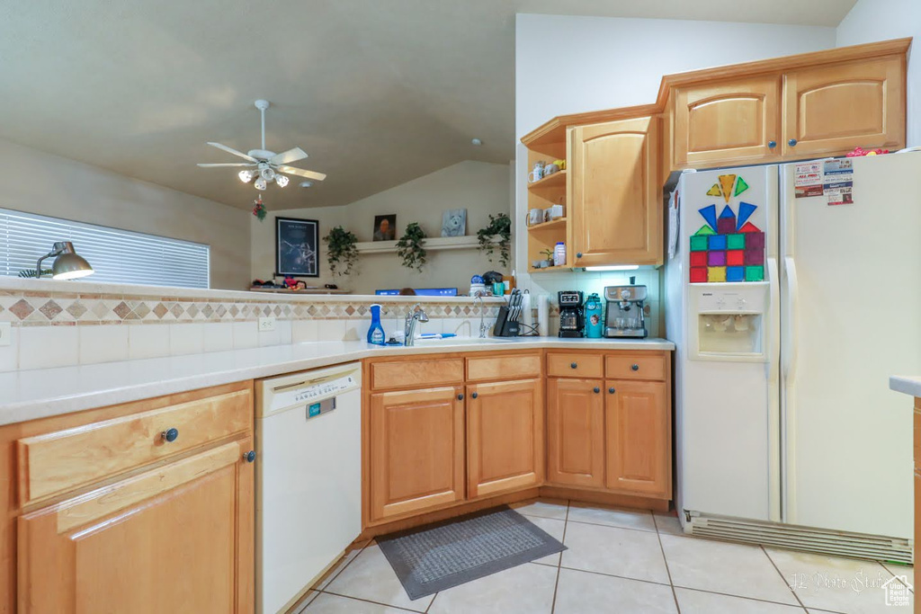 Kitchen featuring white appliances, ceiling fan, sink, light tile flooring, and vaulted ceiling