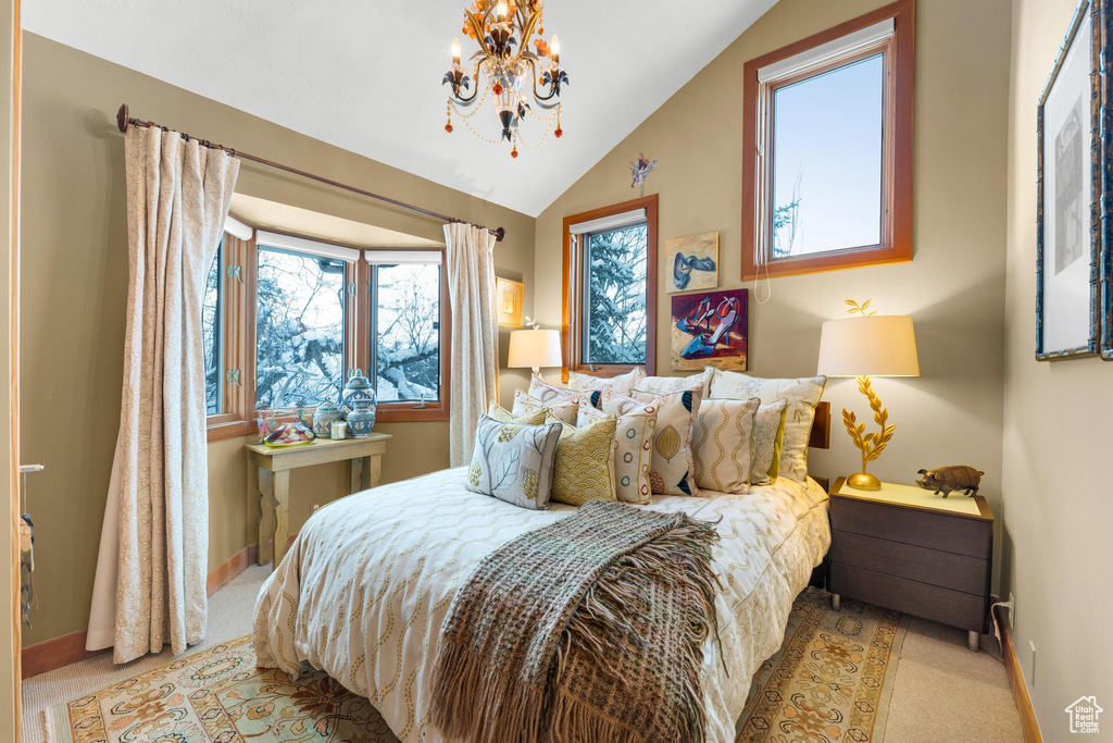 Carpeted bedroom with a chandelier, lofted ceiling, and multiple windows
