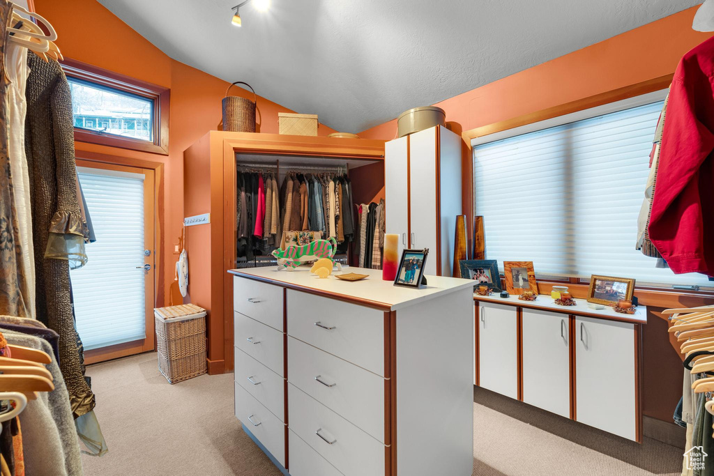 Walk in closet featuring light colored carpet and lofted ceiling