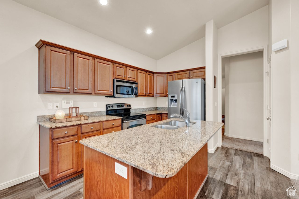 Kitchen featuring a kitchen island with sink, wood-type flooring, and appliances with stainless steel finishes