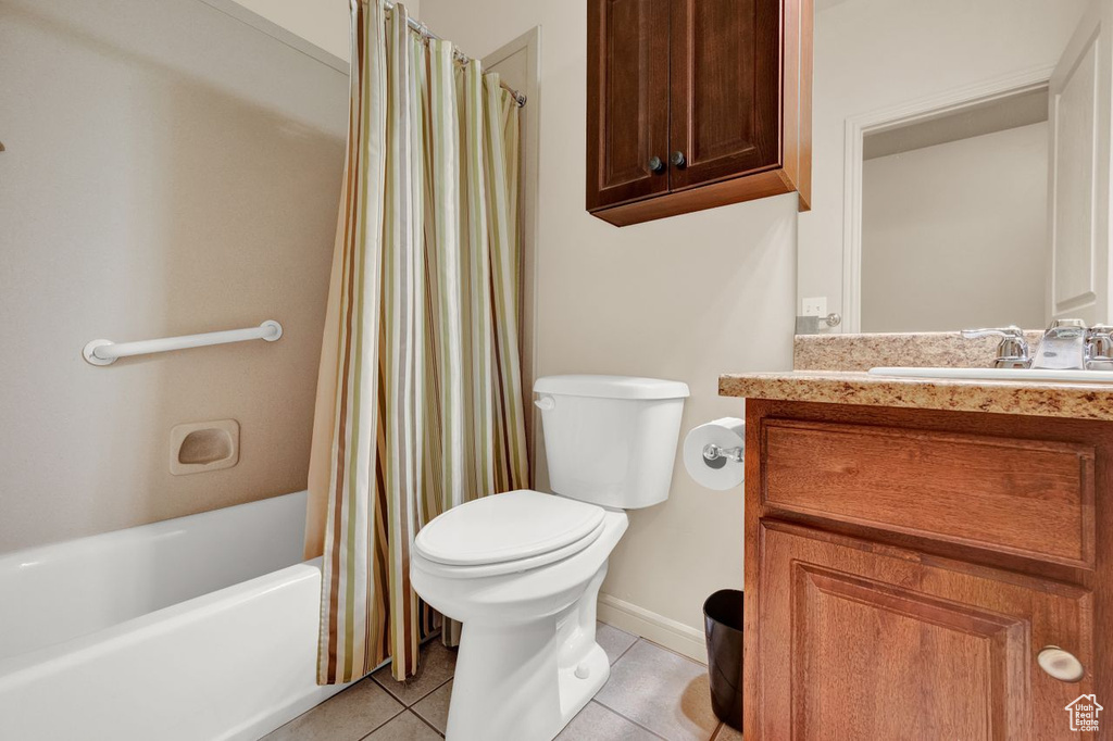 Full bathroom featuring oversized vanity, toilet, tile floors, and shower / bath combo with shower curtain