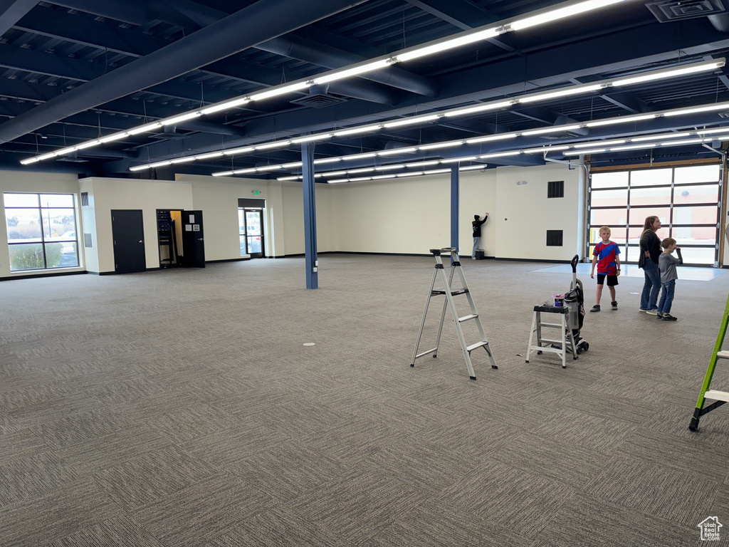 Gym with light colored carpet and a wealth of natural light