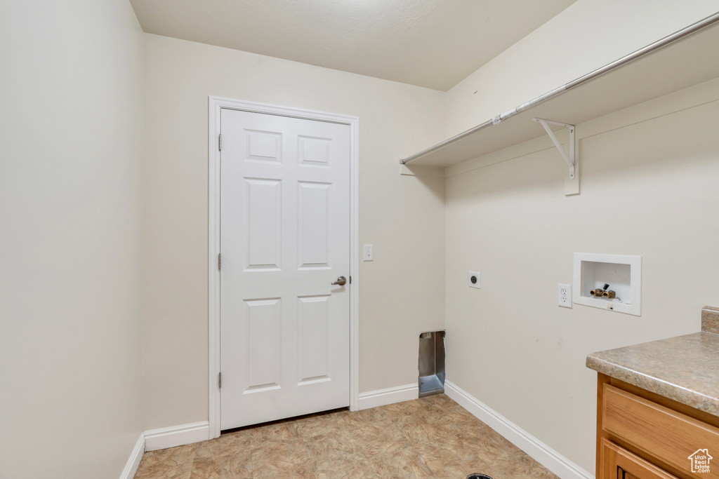 Laundry room with light tile flooring, hookup for a washing machine, and hookup for an electric dryer