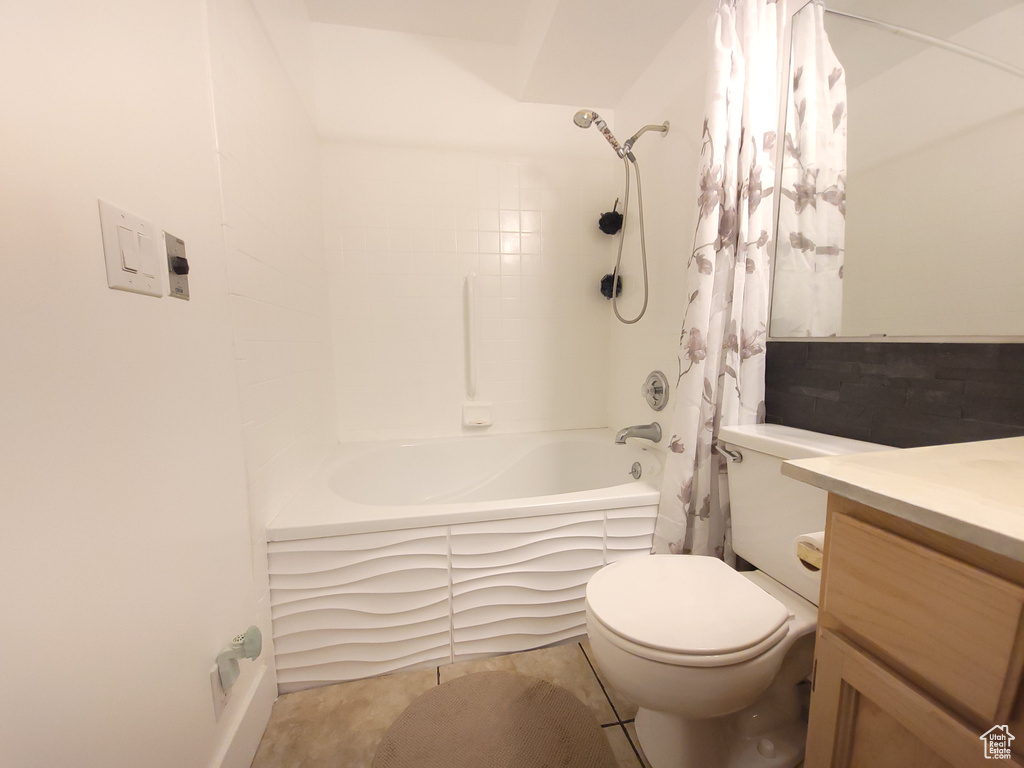 Full bathroom with toilet, shower / tub combo, tile floors, and vanity