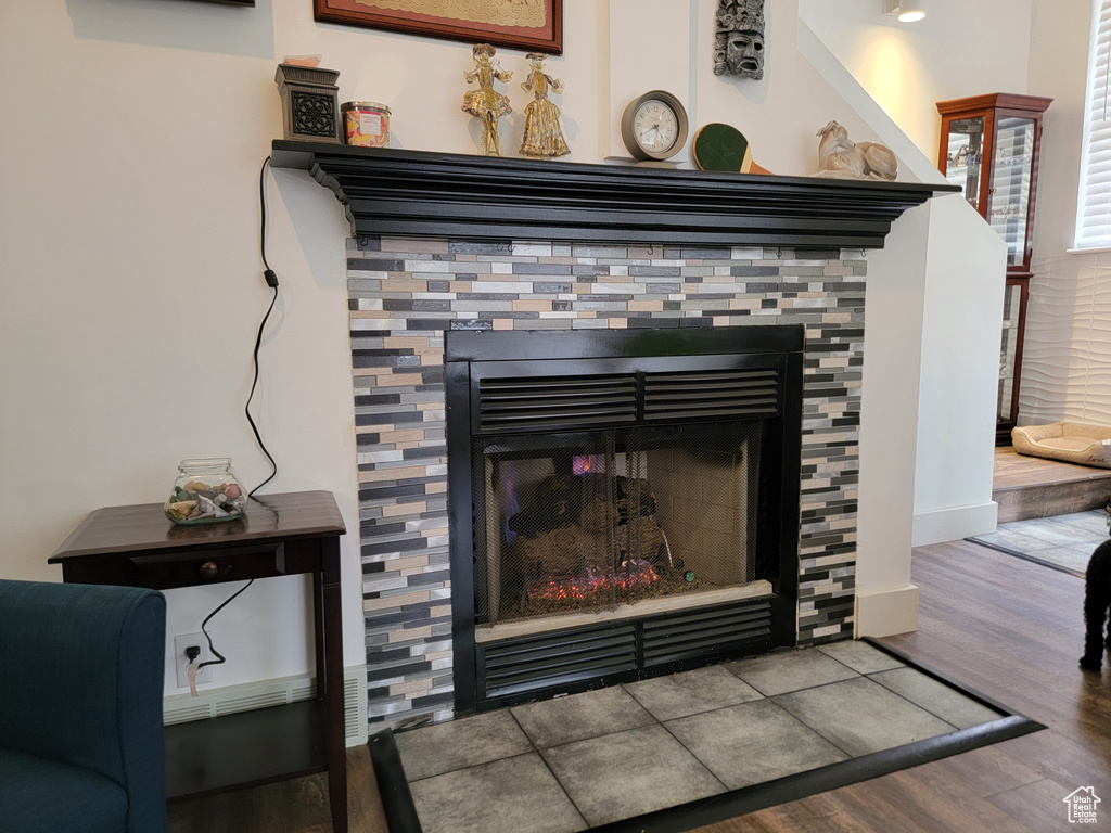 Details with a stone fireplace and wood-type flooring
