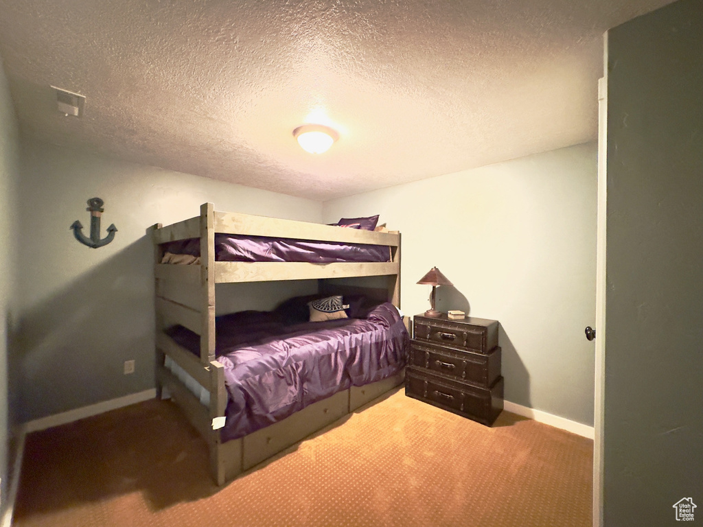 Bedroom with carpet flooring and a textured ceiling