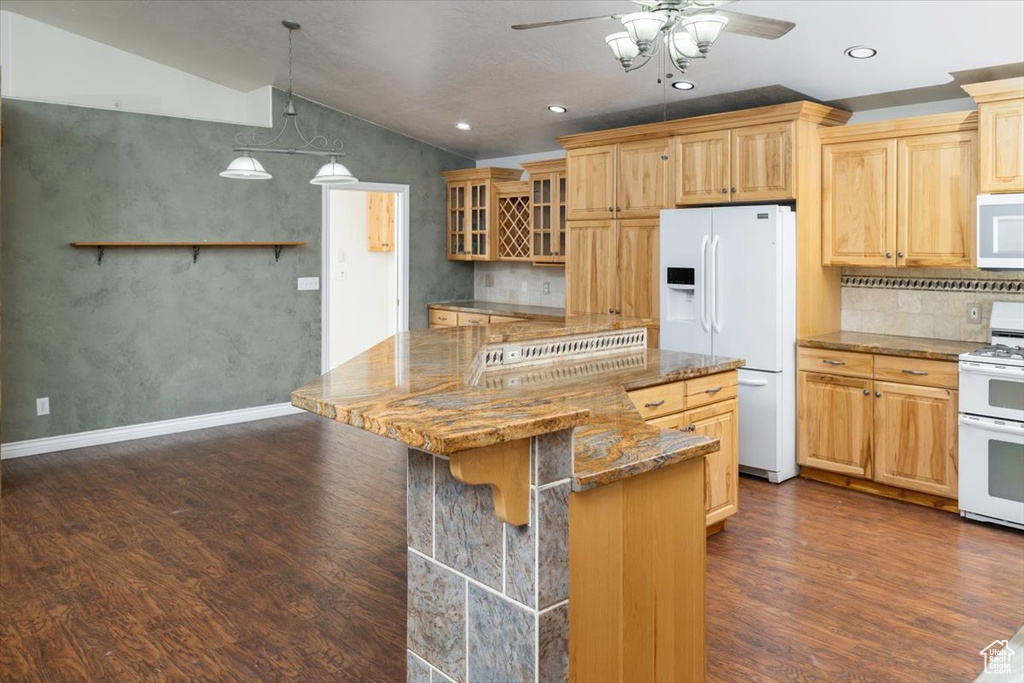 Kitchen with white appliances, ceiling fan, dark hardwood / wood-style flooring, vaulted ceiling, and tasteful backsplash