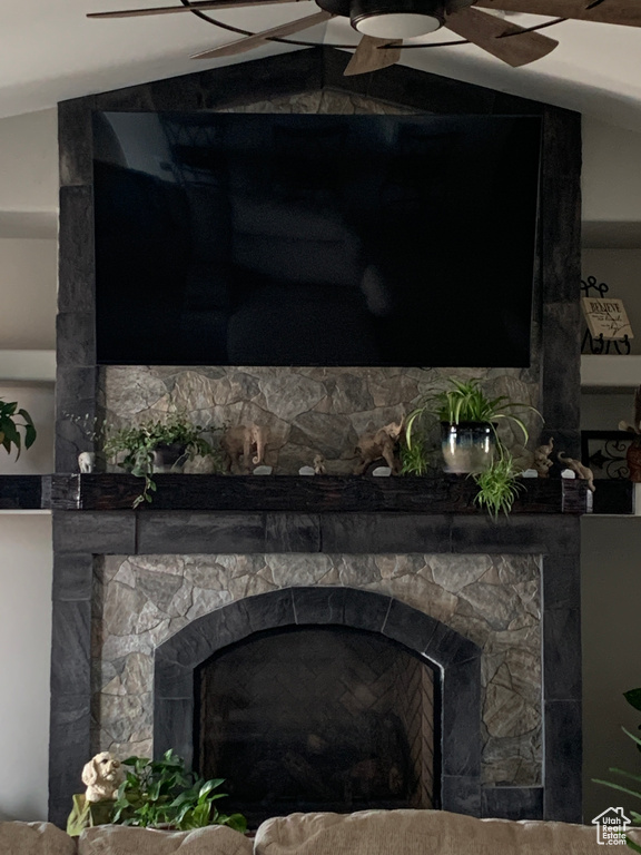 Details featuring a stone fireplace and ceiling fan