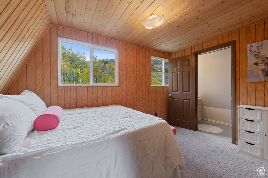 Bedroom with wooden walls, vaulted ceiling, and wooden ceiling