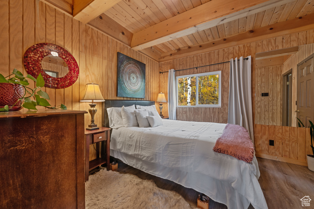 Bedroom with wooden walls, wooden ceiling, hardwood / wood-style floors, and beamed ceiling