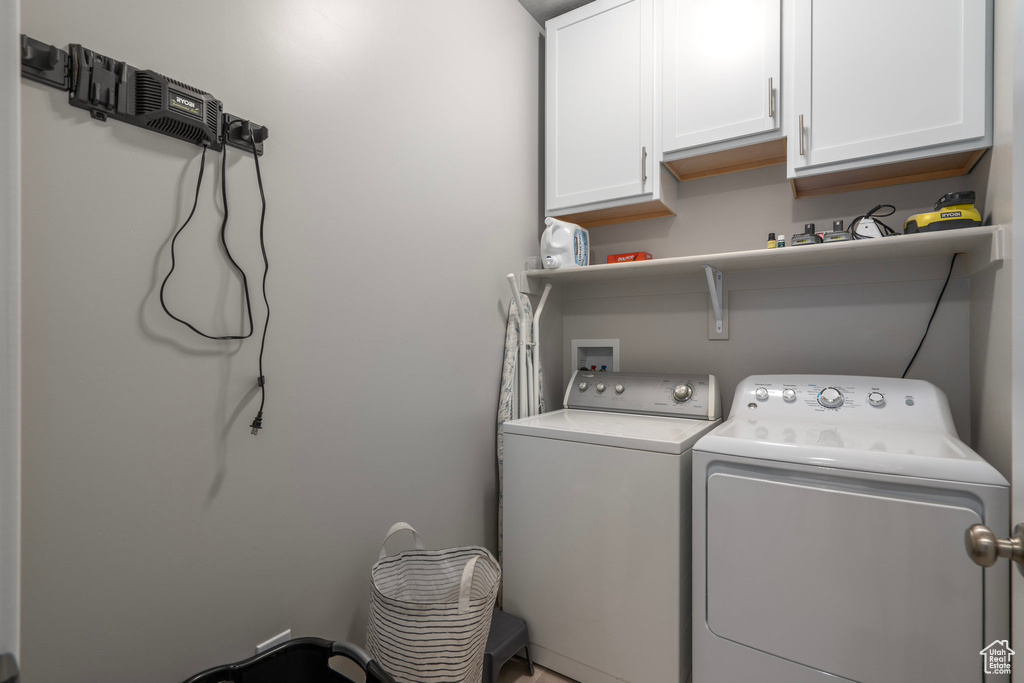 Laundry room with washer hookup, cabinets, and washer and dryer