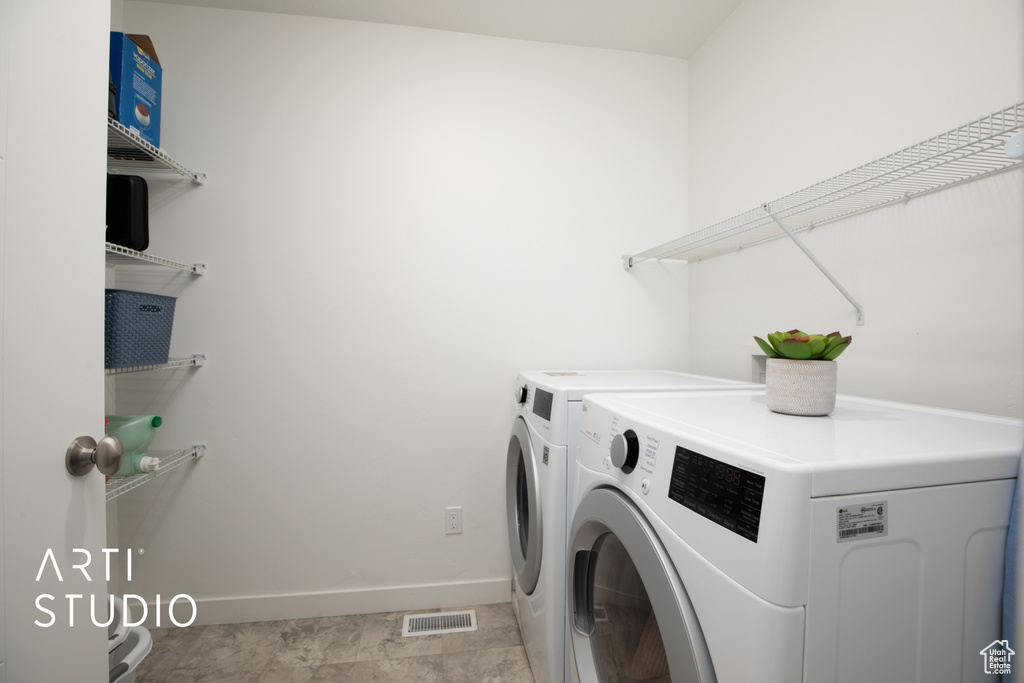Laundry room with light tile flooring and independent washer and dryer