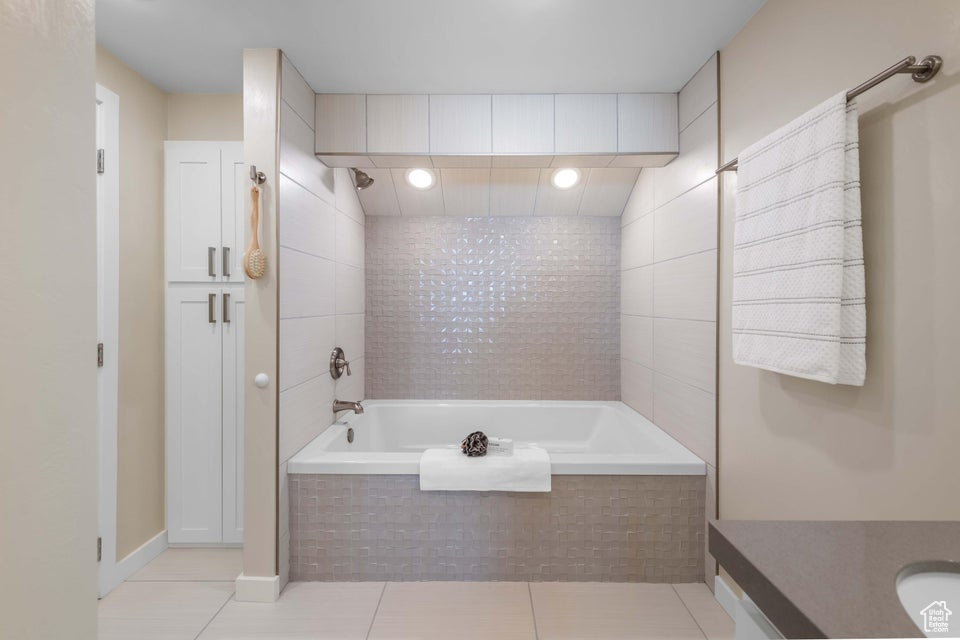 Bathroom with tiled shower / bath, tile walls, and tile floors