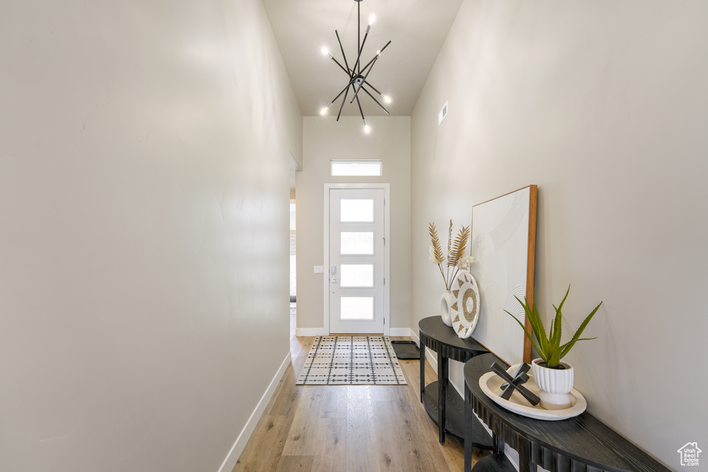 Entryway featuring a chandelier, light hardwood / wood-style floors, and high vaulted ceiling