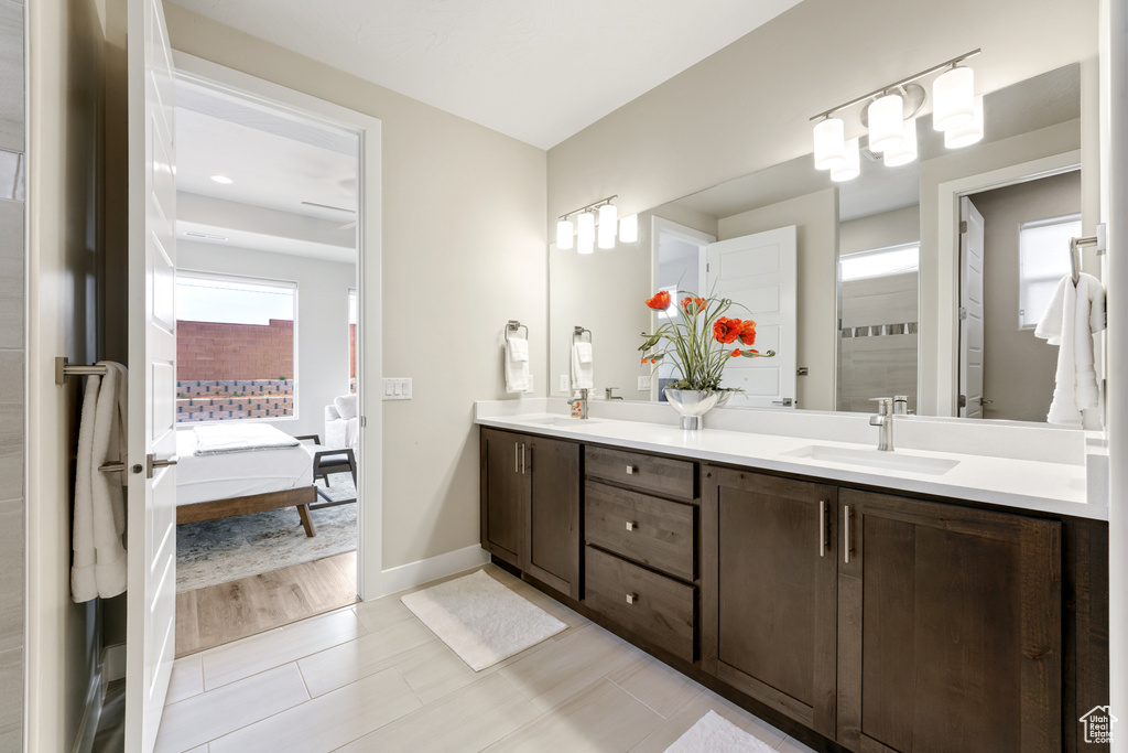 Bathroom featuring hardwood / wood-style floors, dual sinks, and vanity with extensive cabinet space